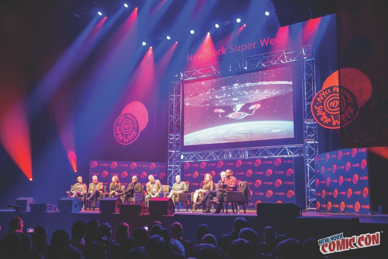 Panel discussions draw as many as 3,000 attendees at a time. Projected visuals tie in with discussion topics. (C) David Lackey