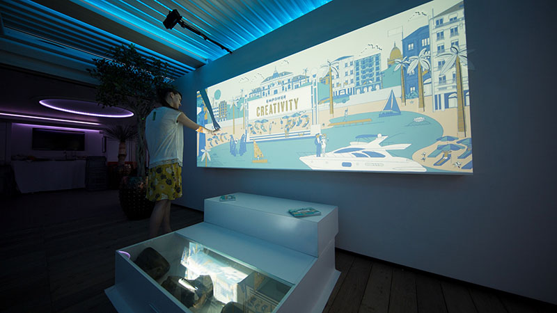 Light Mural’ - was a 10-foot by 4-foot animated scene of beach life featuring Kinect, one Christie DWU951-Q projector with an ultra-short throw lens. When touched, the interactive mural sensed depth changes and came to life with pop-up images.