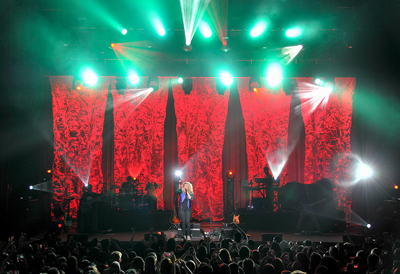 The focus is on the artist and on bold colors as the band plays in silhouette. Photo by Steve Jennings